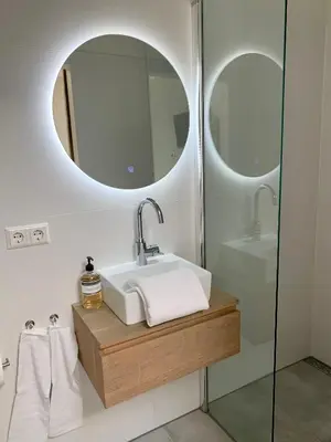 a bathroom with a sink and two mirrors at Beach Studio 35 with private parking in Zandvoort