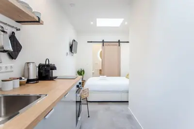a kitchen with a bed in the middle of a room at Beach Studio 35 with private parking in Zandvoort