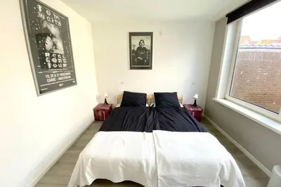 a bedroom with a bed with white sheets and a window at Who's Anton? Monnickendam, vlak bij Amsterdam in Monnickendam