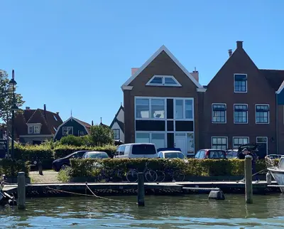 a house with cars parked in front of a marina at Who's Anton? Monnickendam, vlak bij Amsterdam in Monnickendam