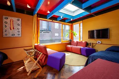 a room with red and purple chairs and a tv at Dreamtime Houseboat in Amsterdam