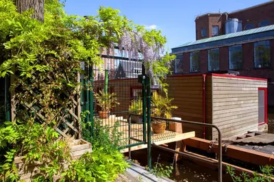 a garden with a bench next to a building at Dreamtime Houseboat in Amsterdam