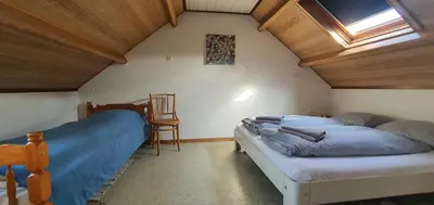a bedroom with two beds in a attic at 'Heerlijk Zomerhuis Vlakbij Strand en Duinen' in Egmond aan Zee