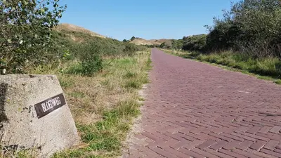 a brick road with a sign on it at 'Heerlijk Zomerhuis Vlakbij Strand en Duinen' in Egmond aan Zee
