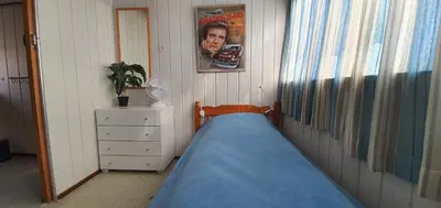 a bedroom with a bed and a picture of a man at 'Heerlijk Zomerhuis Vlakbij Strand en Duinen' in Egmond aan Zee