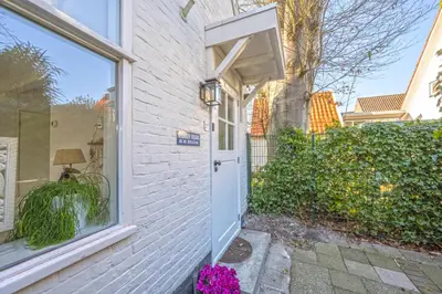 a white brick house with a door and a window at Villa Bo Junior in Bergen