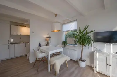 a kitchen and dining room with a white table and chairs at Villa Bo Junior in Bergen