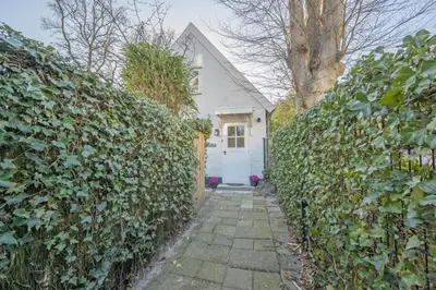 a white house with a white door and a hedge at Villa Bo Junior in Bergen