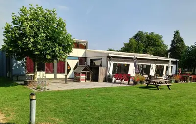 a house with a picnic table in a yard at Vakantiehuis Friedeburg in Warmenhuizen