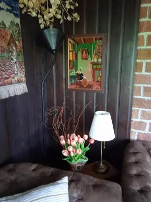 a lamp and a vase of flowers on a table at Vakantiehuis Friedeburg in Warmenhuizen
