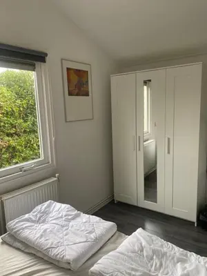 a bedroom with a bed and a large window at Chalet Bergen NH, Schoorl, Schoorldam in Warmenhuizen