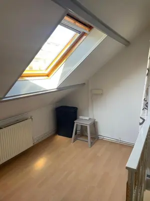 an attic room with a skylight and a table at Torensdoin in Egmond aan Zee