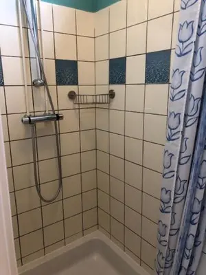 a bathroom with a shower with a shower curtain at Torensdoin in Egmond aan Zee