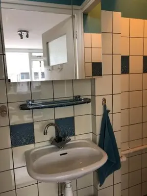 a bathroom with a sink and a mirror at Torensdoin in Egmond aan Zee