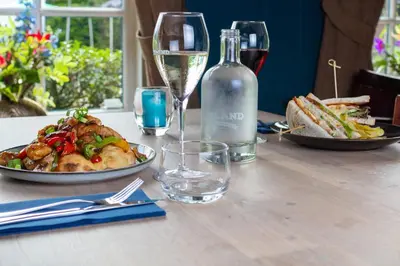 a table with a plate of food and a bottle of wine at Grandcafé Boutique Hotel Eemland in Eemnes