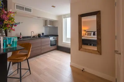 a kitchen with a table and a mirror on the wall at Grandcafé Boutique Hotel Eemland in Eemnes