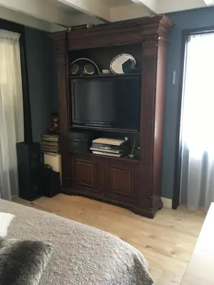 a entertainment center with a television in a bedroom at B&B De Kamer in Wervershoof