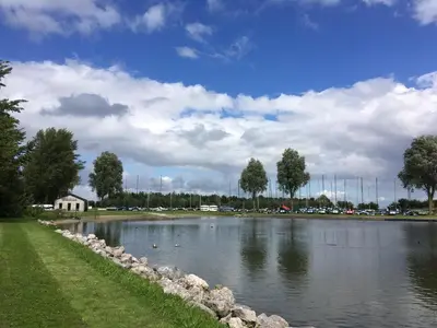 a large lake with ducks in the water at B&B De Kamer in Wervershoof