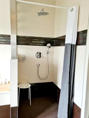 a shower stall with a stool in a bathroom at Appartement Schoorl in Schoorl
