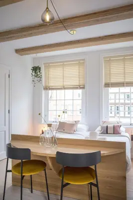 a bedroom with a bed and a wooden table and two chairs at Studios at the canal in Amsterdam