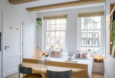 a living room with a white couch and a table at Studios at the canal in Amsterdam