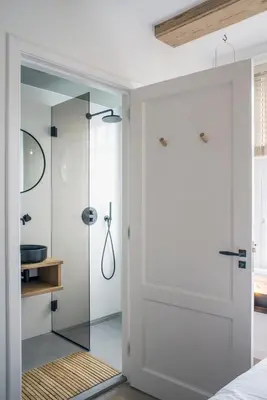 a bathroom with a glass shower with a glass door at Studios at the canal in Amsterdam