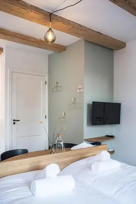 a bedroom with a bed and a tv on the wall at Studios at the canal in Amsterdam