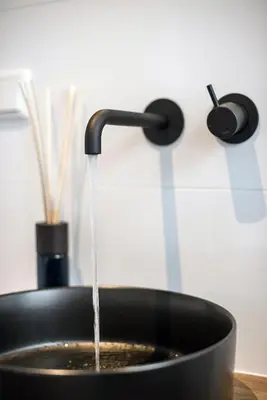 a black sink with water coming out of it at Studios at the canal in Amsterdam