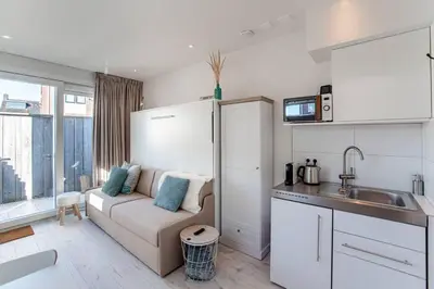 a kitchen and living room with a couch and a sink at Studio Jadana in Zandvoort