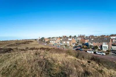 a town with cars parked on a hill next to the ocean at Studio Jadana in Zandvoort