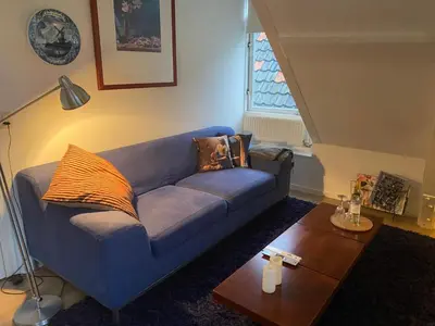 a blue couch in a living room with a table at Park View Apartment in Amsterdam