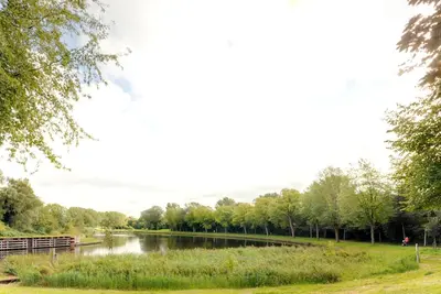 a view of a river with trees in the background at Park View Apartment in Amsterdam