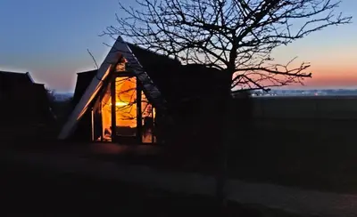 a small house with the sun shining in the window at Hotelhuisje Warmenhuizen #A in Warmenhuizen