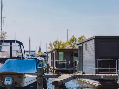 a small house and a boat in a marina at Holiday Home Havenlodge by Interhome in Uitgeest