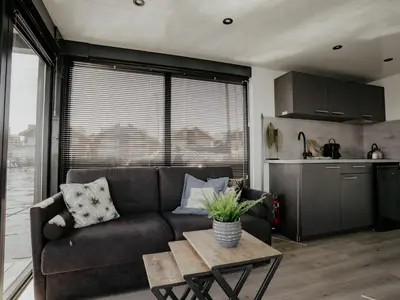a living room with a couch and a table at Holiday Home Havenlodge by Interhome in Uitgeest