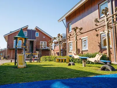 a playground in front of a building at Holiday Home Havenlodge by Interhome in Uitgeest