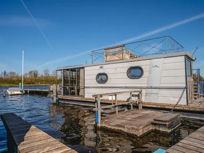 a boat docked at a dock on the water at Holiday Home Campi 400 by Interhome in Uitgeest