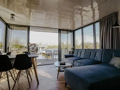 a living room with a blue couch and a table at Holiday Home Campi 400 by Interhome in Uitgeest