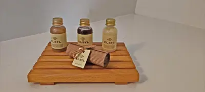 three bottles of sauce on a wooden cutting board at Hotelhuisje Warmenhuizen #B in Warmenhuizen