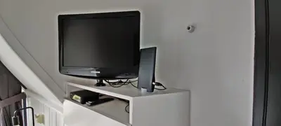 a flat screen tv sitting on a white cabinet at Hotelhuisje Warmenhuizen #C in Warmenhuizen