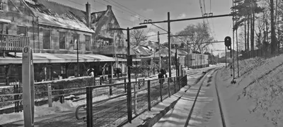 a black and white photo of a snow covered train station at Hotelhuisje Warmenhuizen #C in Warmenhuizen