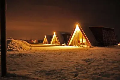 a group of lodges in the snow at night at Hotelhuisje Warmenhuizen #D in Warmenhuizen