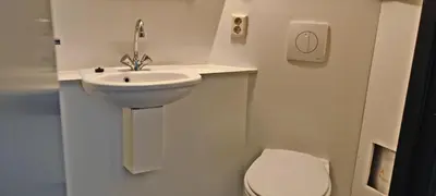 a white bathroom with a sink and a toilet at Hotelhuisje Warmenhuizen #E in Warmenhuizen