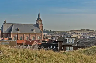a group of buildings with a church and a tower at Hotelhuisje Warmenhuizen #E in Warmenhuizen