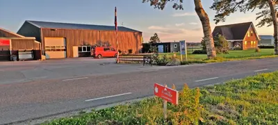 a red sign on the side of a road next to a building at Hotelhuisje Warmenhuizen #F in Warmenhuizen