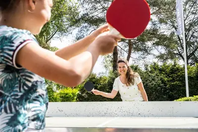 a woman holding a tennis racket and a ball at De Krakeling in Zeist