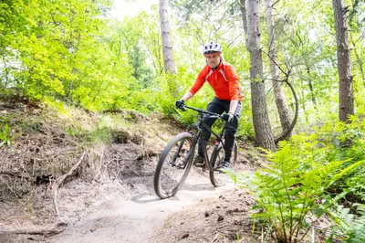 a man riding a bike on a dirt trail at De Krakeling in Zeist