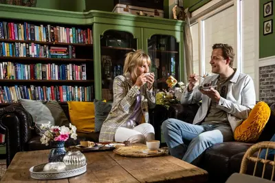 a man and woman sitting in a library drinking wine at De Krakeling in Zeist