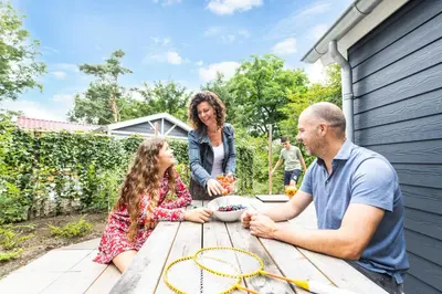 a family sitting at a picnic table with tennis rackets at De Krakeling in Zeist