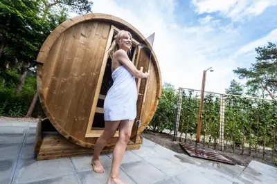 a woman in a dress standing next to a wooden barrel at De Krakeling in Zeist